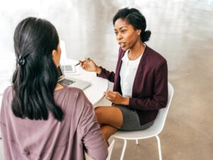 Twp professional women having a discussion sitting at a table