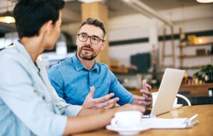 Two male professionals meet in a cafe