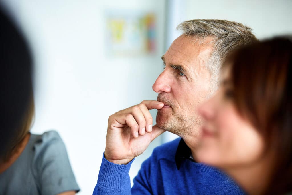 Shot of a group of colleagues listening to a presentation in an office