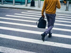 Man walks across the street at a zebra crossing