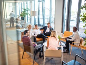 A group of people sitting in a modern office and having a discussion