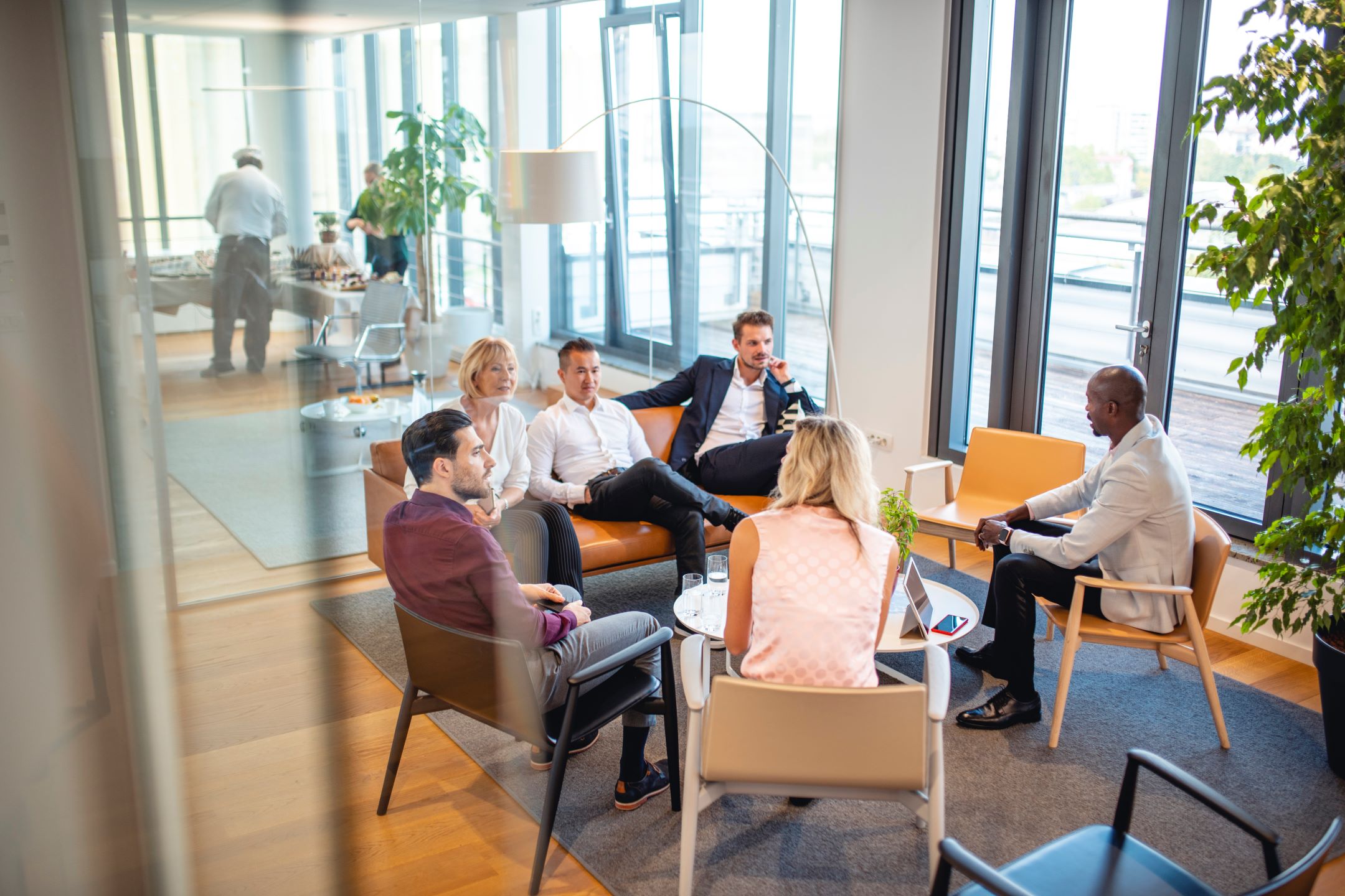 A group of people sitting in a modern office and having a discussion