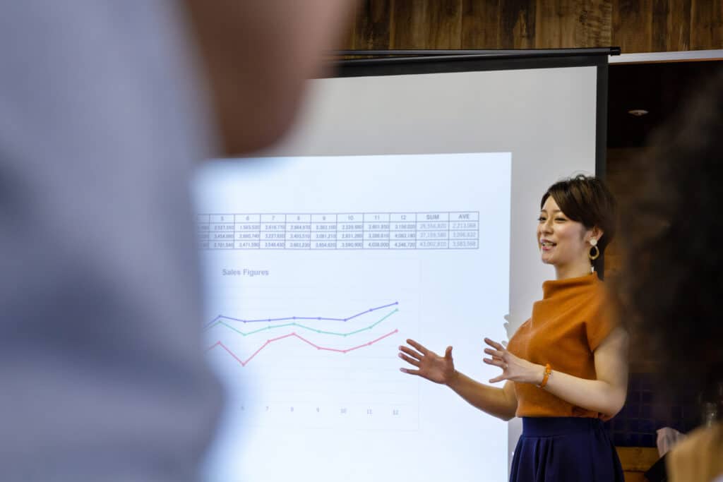 professional woman presenting graphs in front of crowd