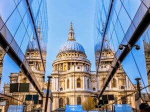 St Paul's cathedral through a glass alleyway against blue sky