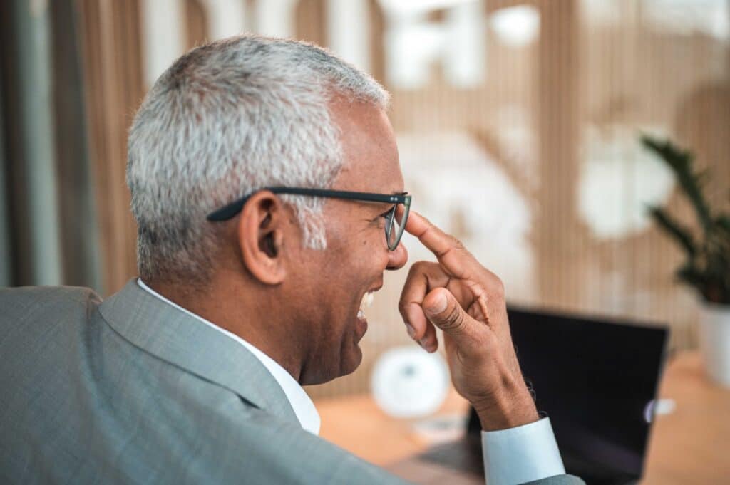 Side view of a smiling mature Hispanic human resources manager wearing eyeglasses in a modern office.