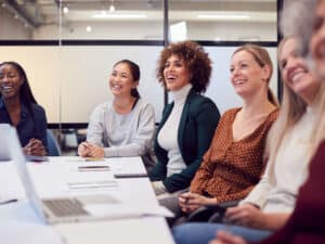 An image of a group of smiling women in a meeting