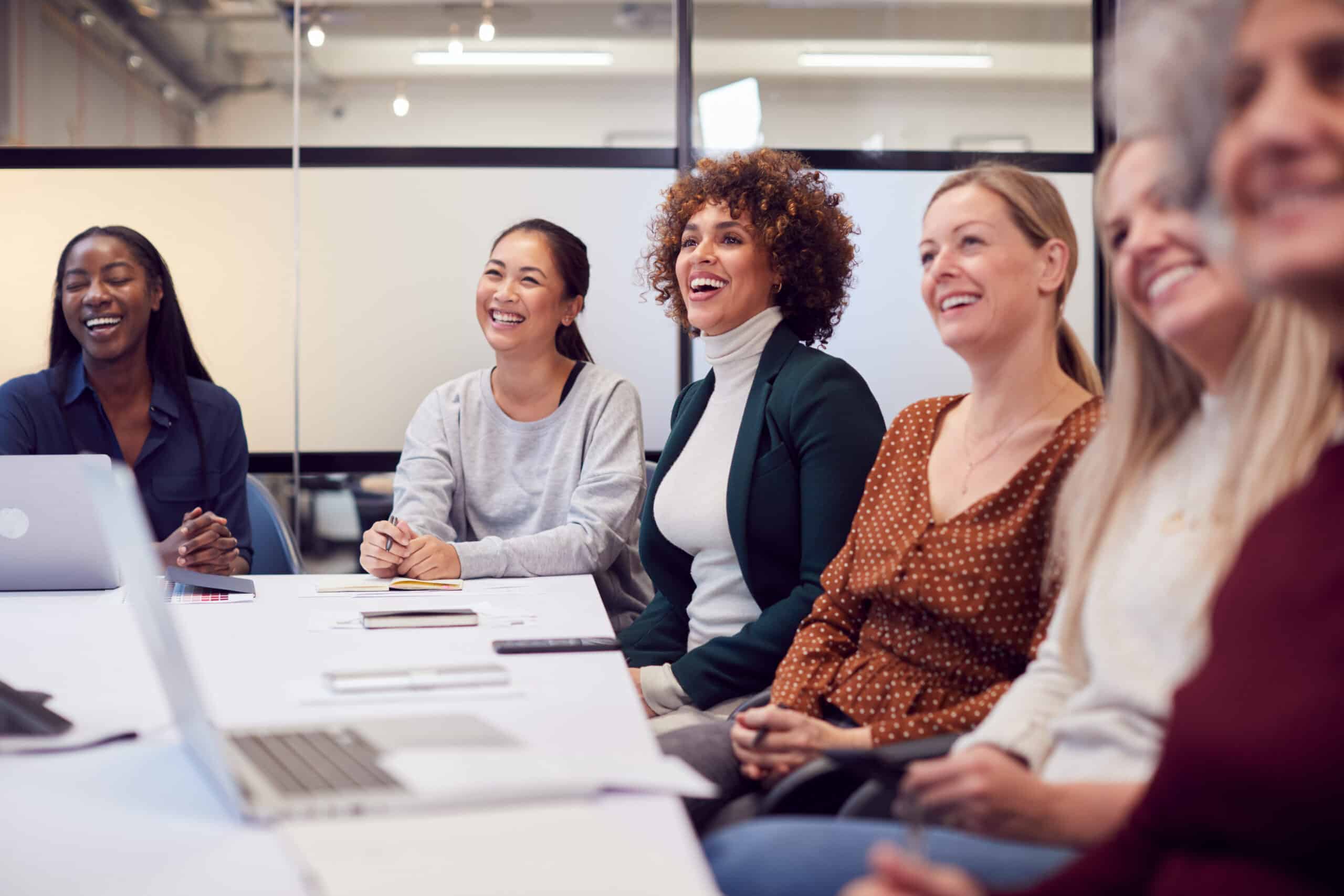 An image of a group of smiling women in a meeting