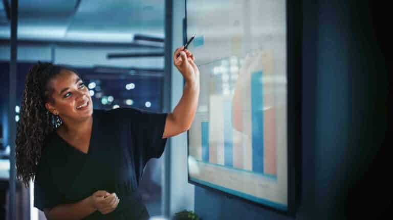 Woman pointing at screen presenting graph