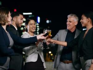 A group of business people cheering outside on a warm evening